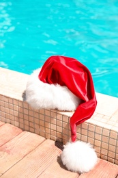 Photo of Authentic Santa Claus hat near pool at resort