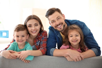 Happy family with cute children on sofa indoors