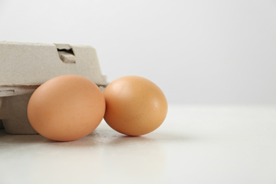 Photo of Raw brown chicken eggs on white table