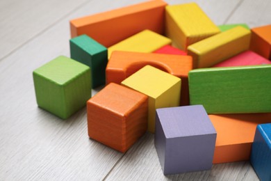 Colorful building blocks on wooden floor, closeup