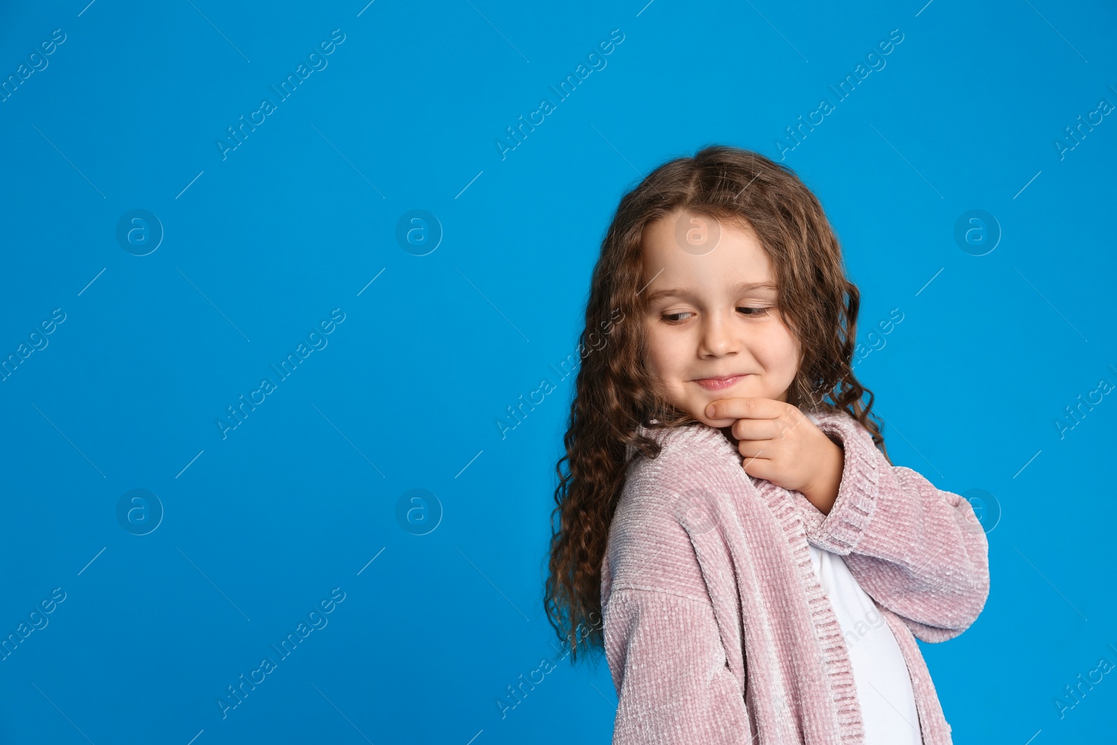 Photo of Portrait of cute little girl on light blue background. Space for text