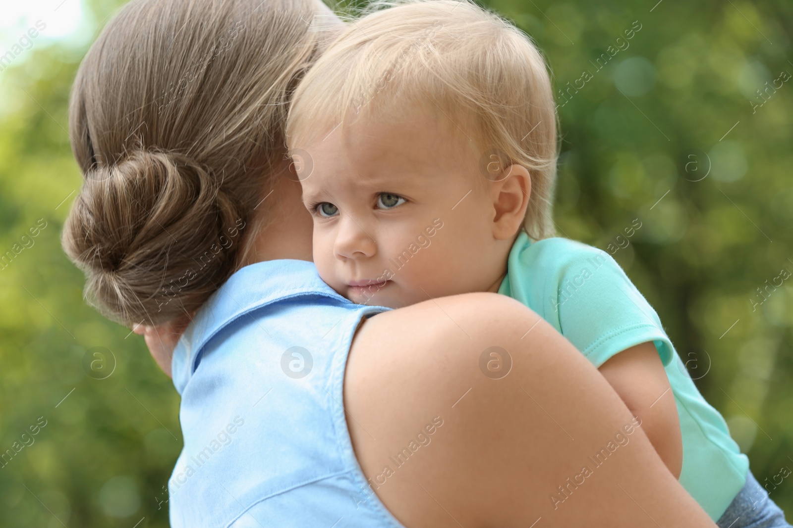 Photo of Young mother with her cute child in green park