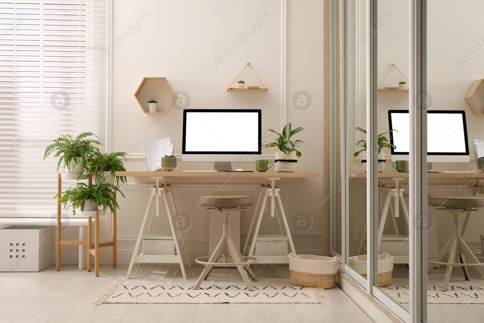 Photo of Comfortable workplace with modern computer and houseplants in room. Interior design