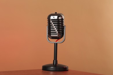 Photo of Vintage microphone on table against color background. Sound recording and reinforcement