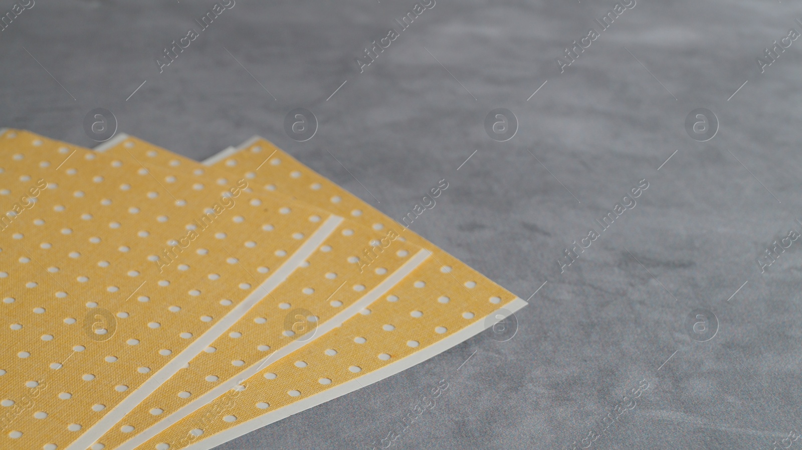 Photo of Pepper plasters on grey textured background, closeup. Space for text