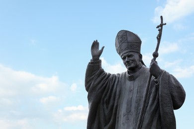 LVIV, UKRAINE - MAY, 04, 2022: Statue of Pope John Paul II against cloudy sky, space for text