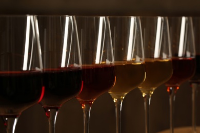 Glasses of different wines against blurred background, closeup. Expensive collection