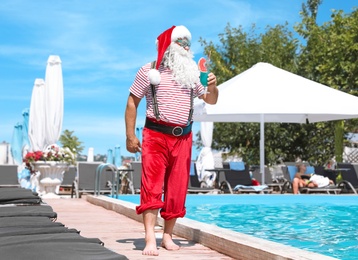 Authentic Santa Claus with cocktail near pool at resort