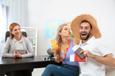 Photo of Beautiful young couple visiting travel agency office