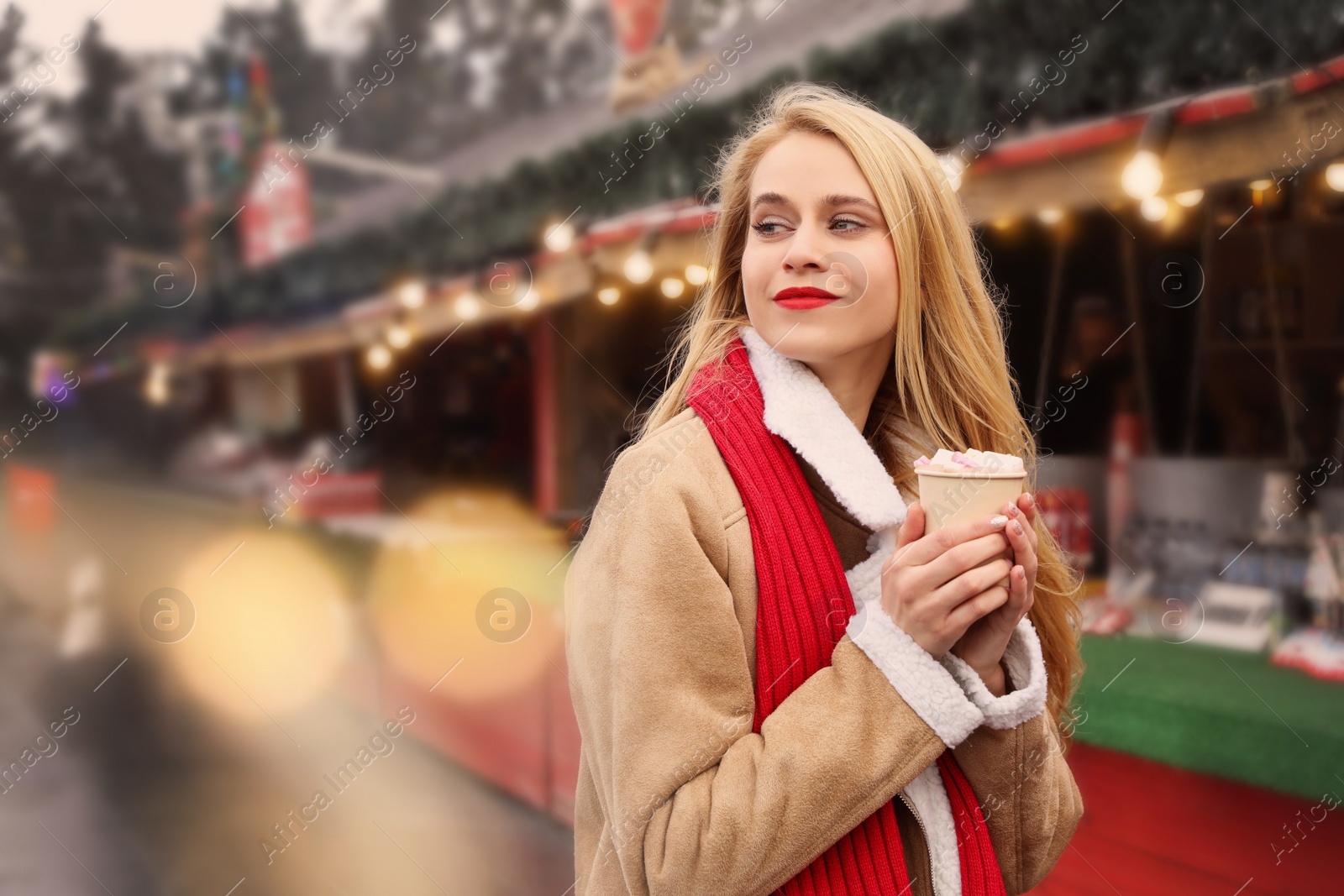 Photo of Young woman with hot drink at Christmas fair