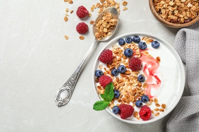 Photo of Healthy homemade granola with yogurt and berries served on light grey table, flat lay. Space for text