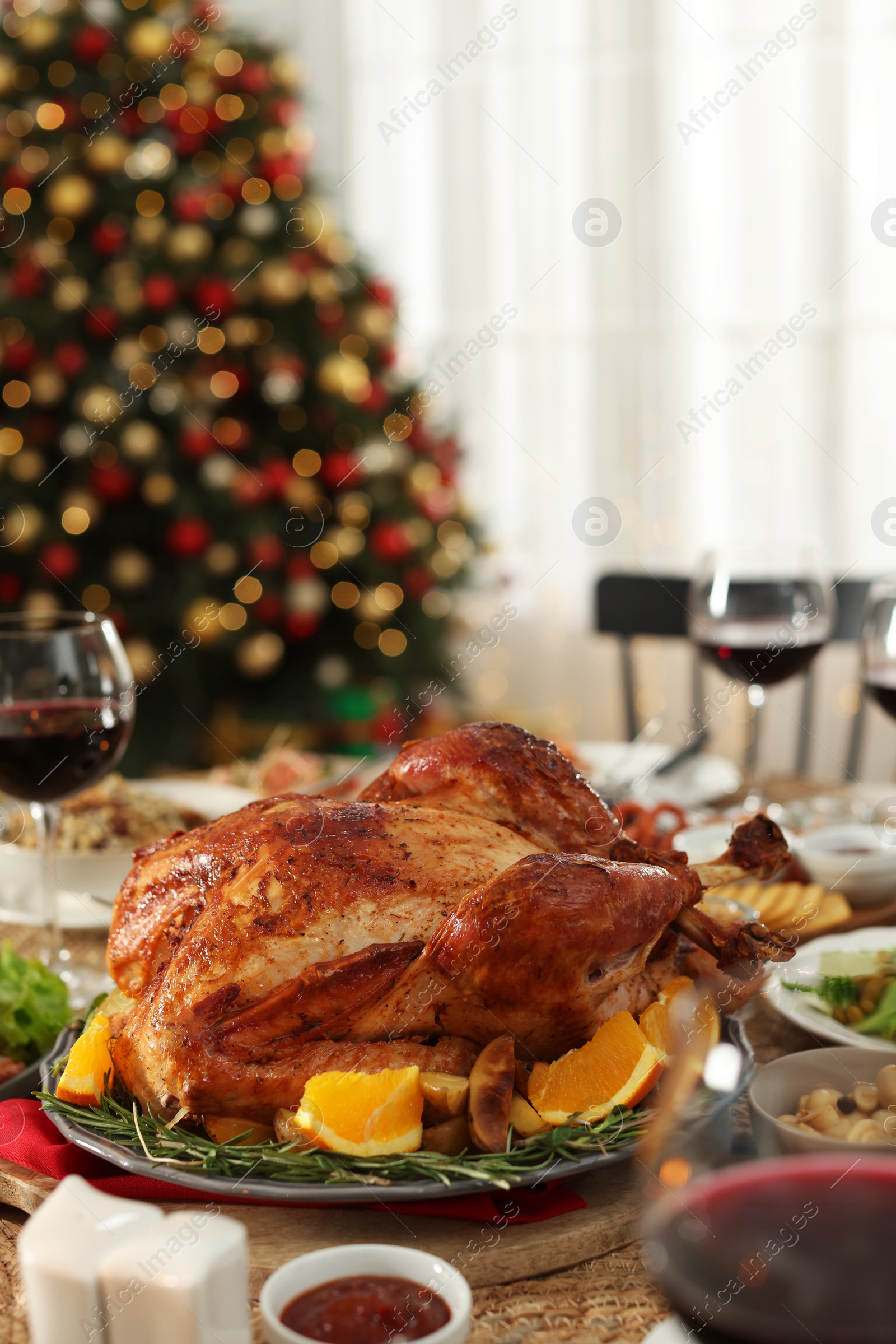 Photo of Festive dinner with delicious baked turkey served on table indoors. Christmas celebration