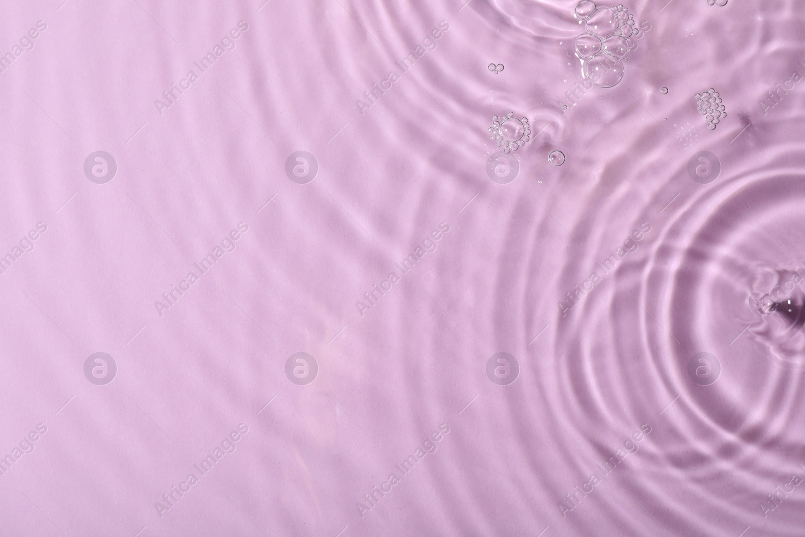 Photo of Closeup view of water with rippled surface on violet background