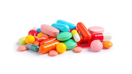 Photo of Pile of different colorful pills on white background