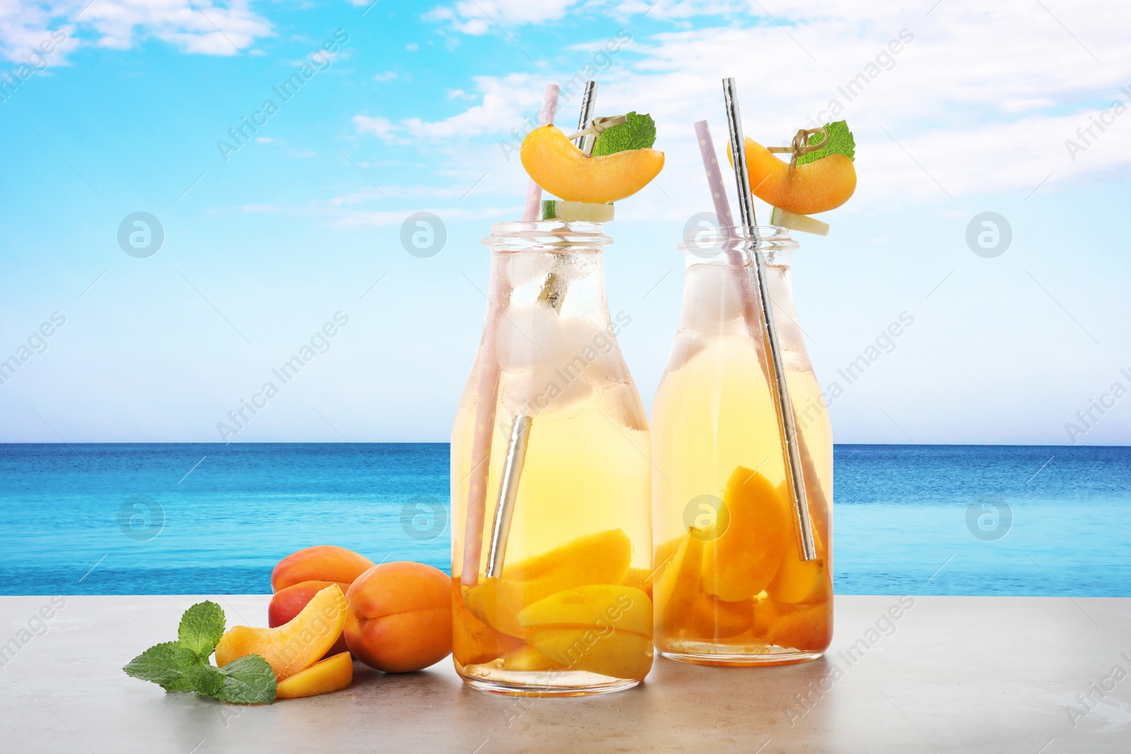 Image of Tasty refreshing drink on table against sea