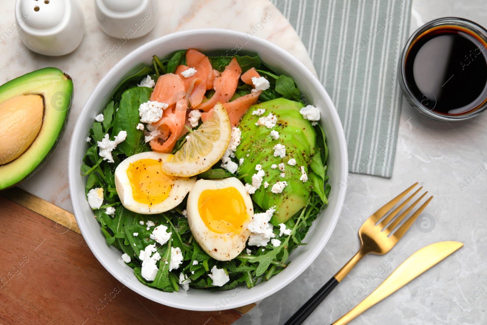 Photo of Delicious salad with boiled egg, salmon and cheese served on light grey marble table, flat lay