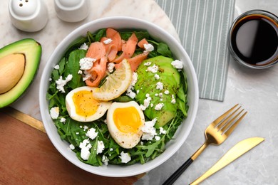 Photo of Delicious salad with boiled egg, salmon and cheese served on light grey marble table, flat lay