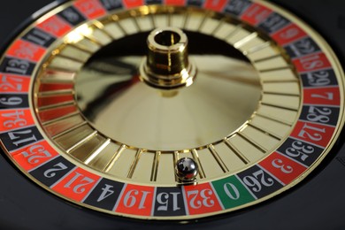 Photo of Roulette wheel with ball, closeup. Casino game