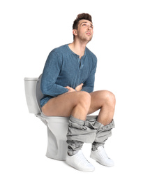 Photo of Man suffering from stomach ache on toilet bowl, white background