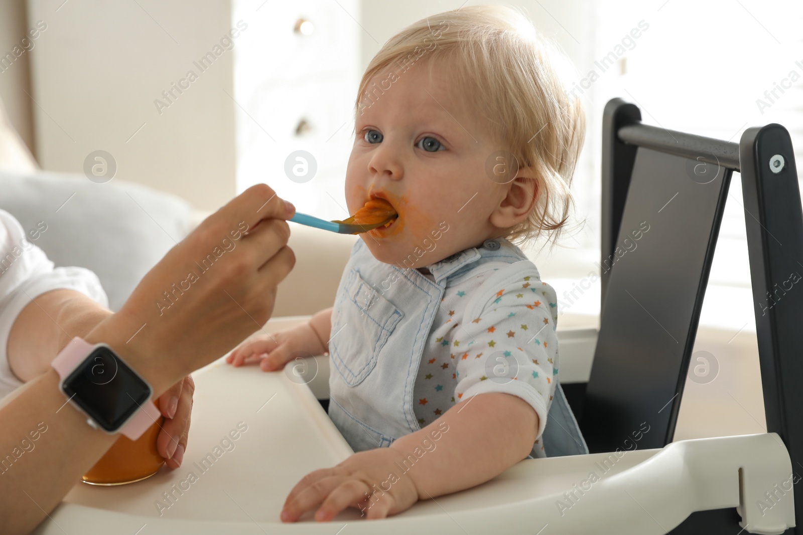 Photo of Mother feeding her cute little baby with healthy food at home