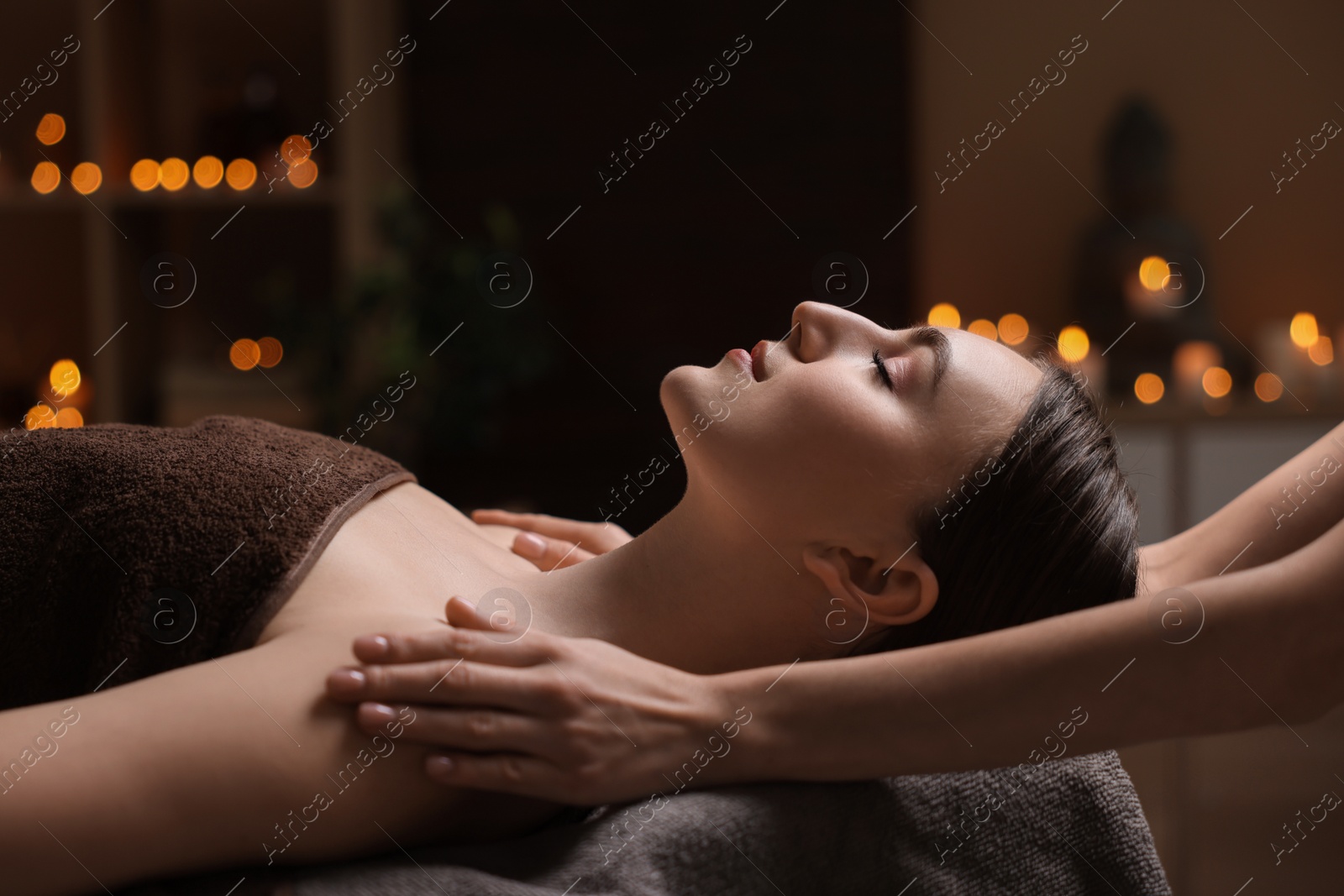 Photo of Spa therapy. Beautiful young woman lying on table during massage in salon