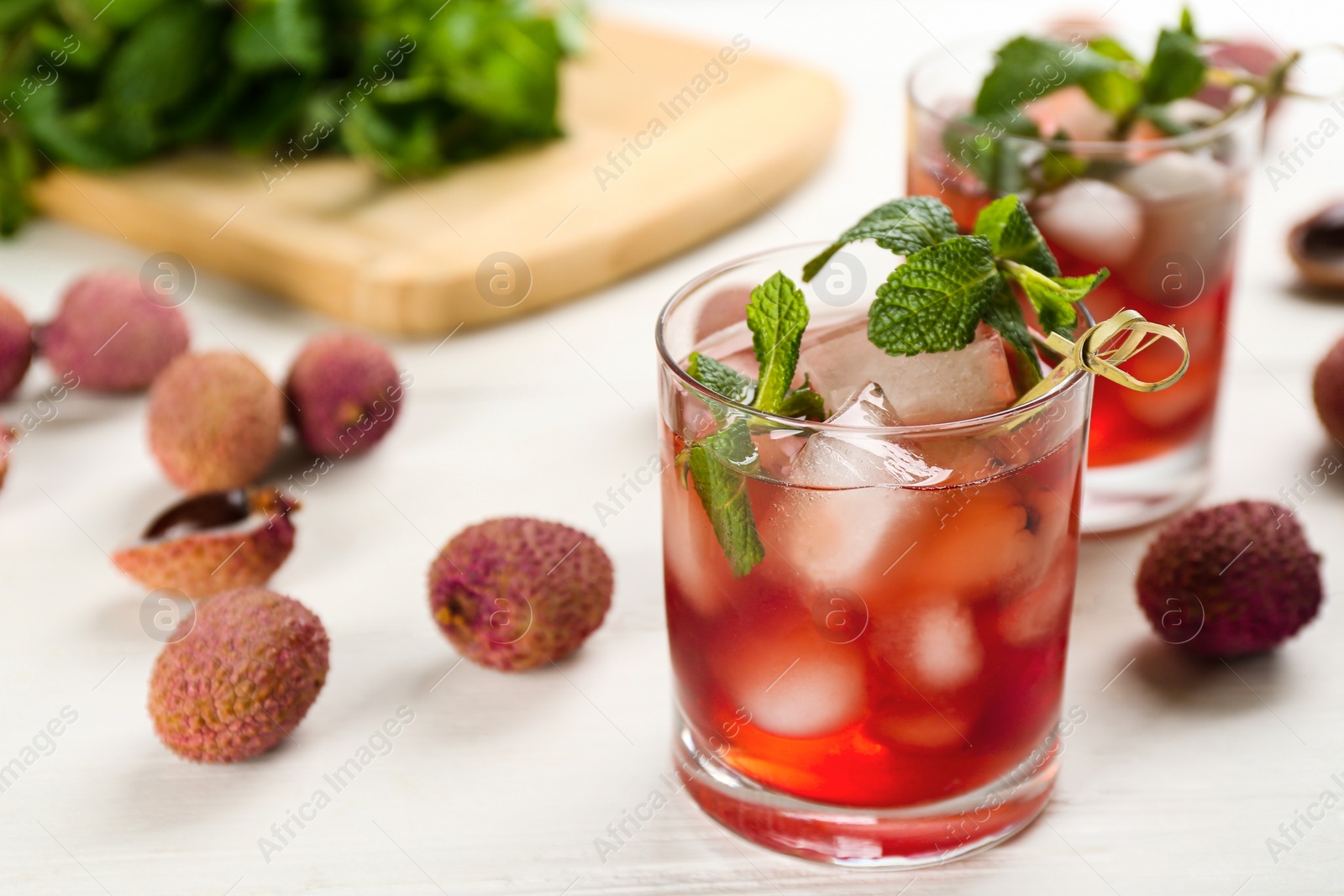 Photo of Lychee cocktail with mint and ice on white table