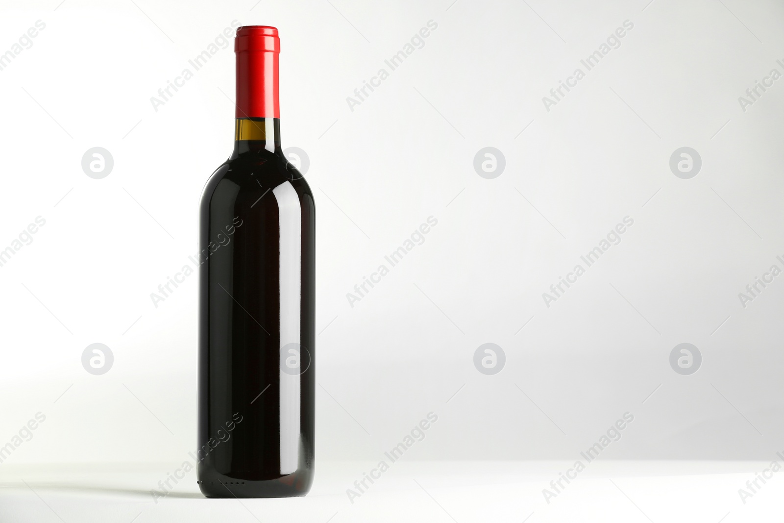 Photo of Bottle of expensive red wine on white background. Space for text