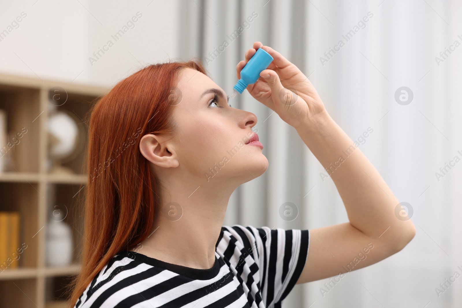 Photo of Woman applying medical eye drops at home