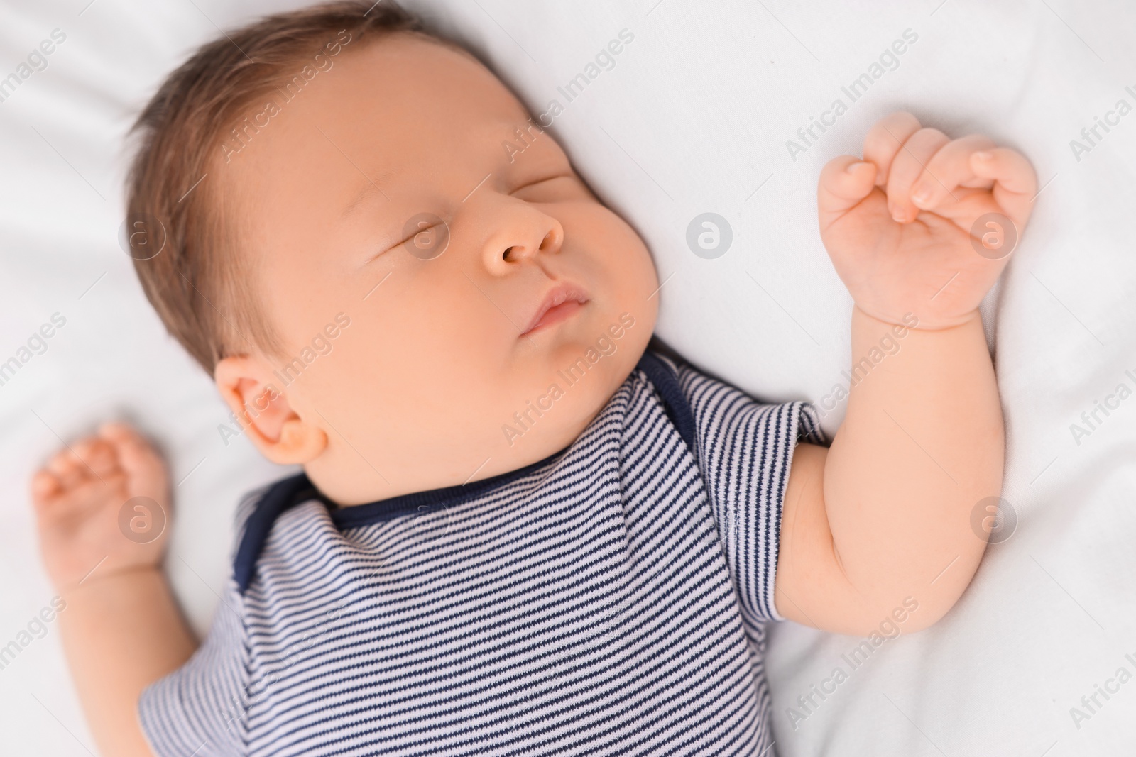 Photo of Cute newborn baby sleeping on white bed