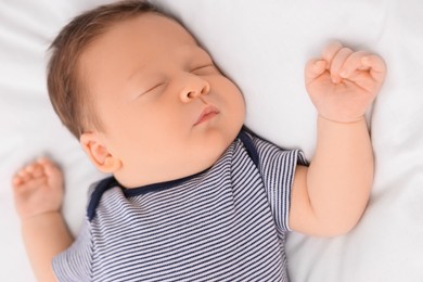 Cute newborn baby sleeping on white bed