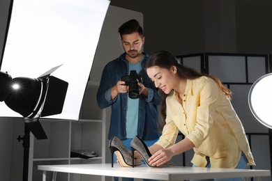 Professional photographers shooting stylish shoes in studio