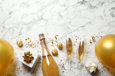 Photo of Flat lay composition with bottle of champagne for celebration on white marble background. Space for text