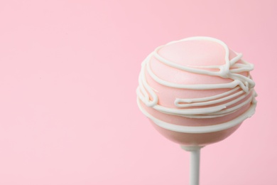 Sweet decorated cake pop on pink background, space for text