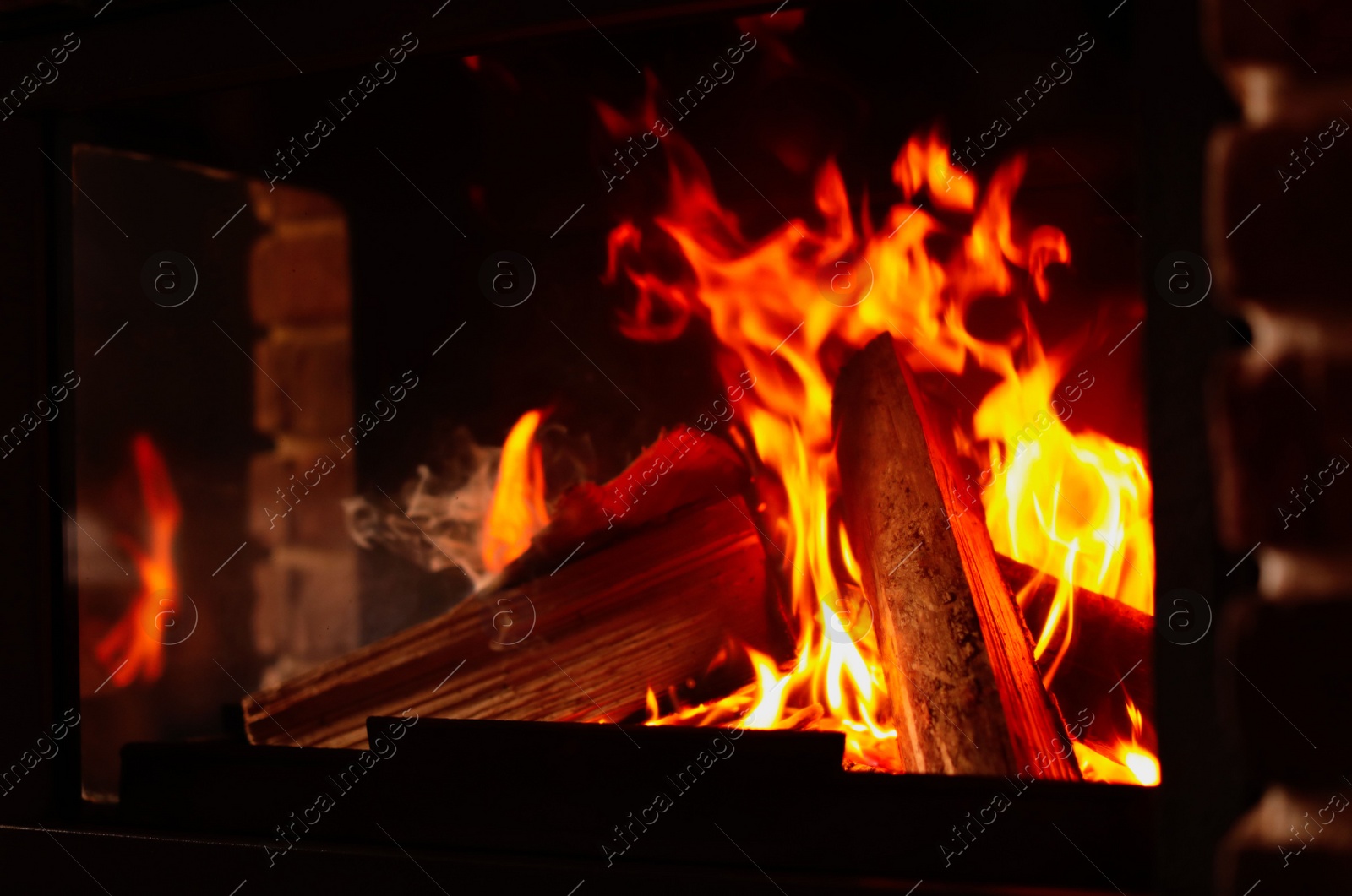 Photo of Fireplace with burning wood, closeup view. Winter vacation