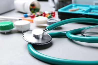 Stethoscope and other medical objects on grey table