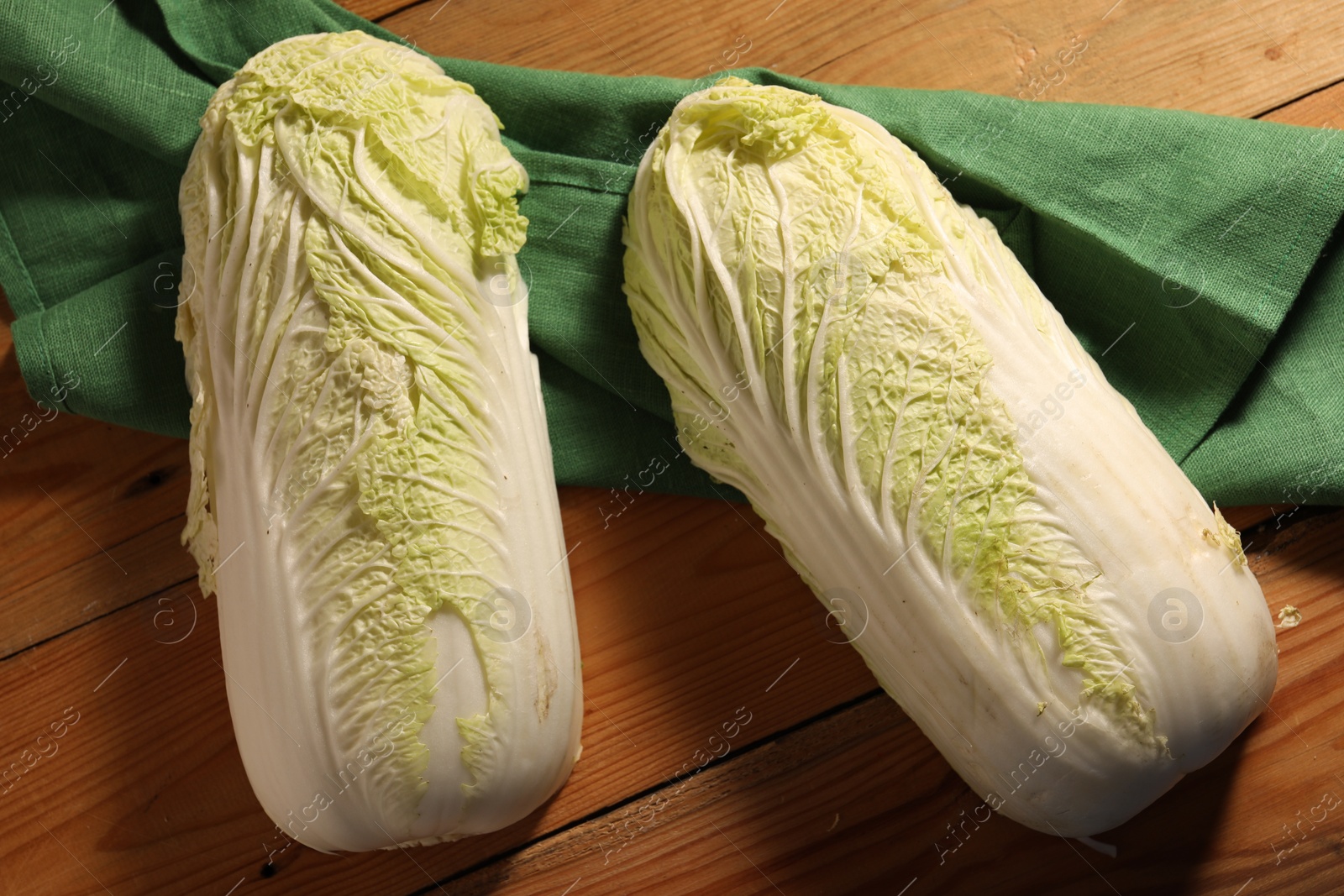 Photo of Fresh Chinese cabbages on wooden table, top view