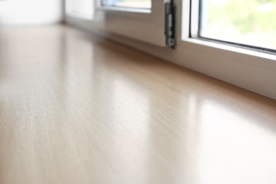 Photo of Closeup of plastic window with wooden sill