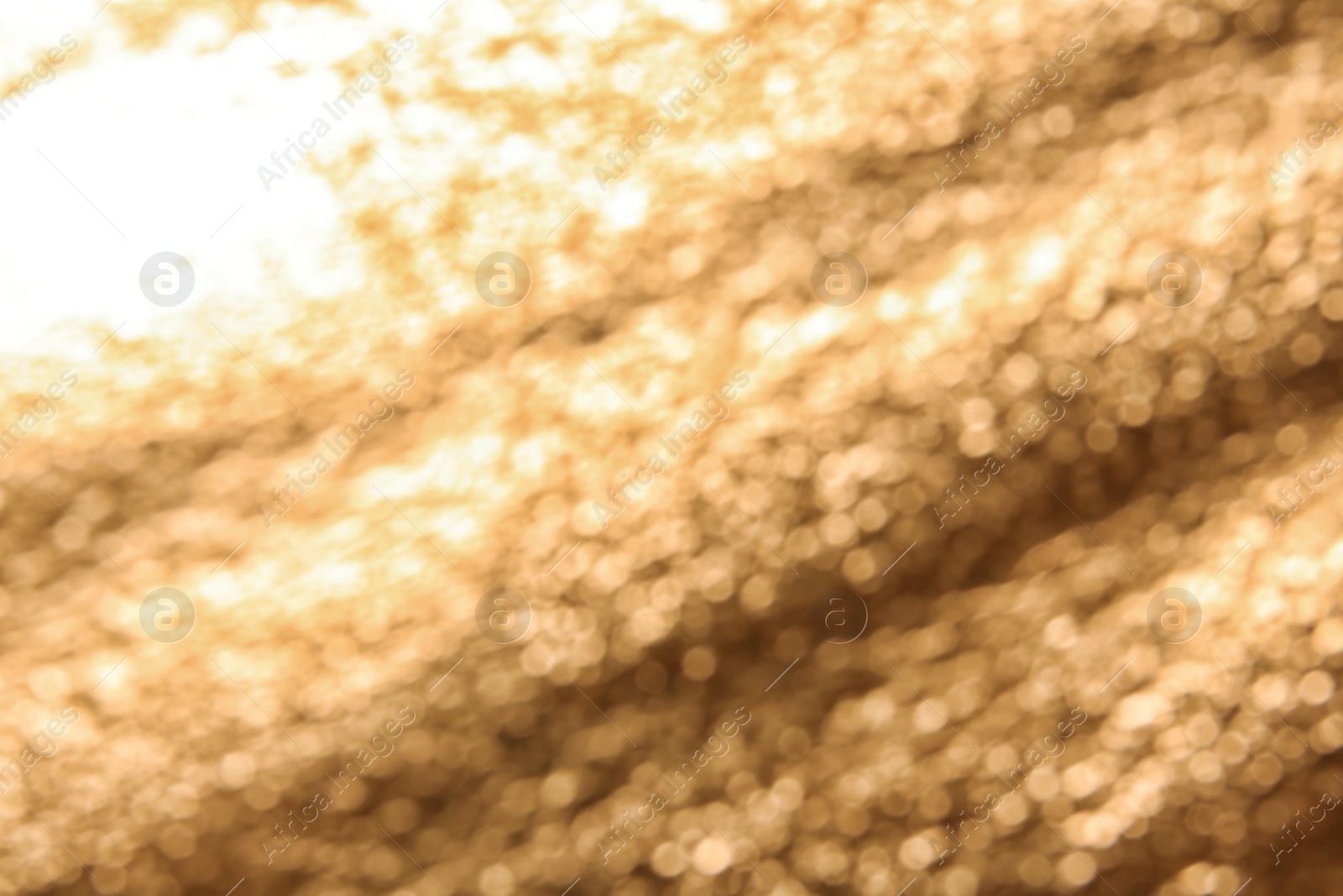 Photo of Blurred view of rough golden surface as background, closeup