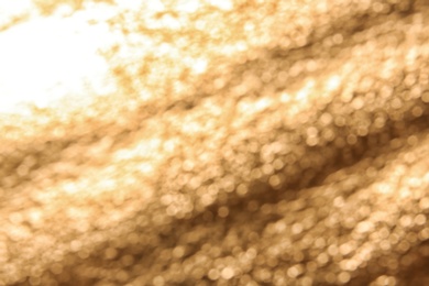 Photo of Blurred view of rough golden surface as background, closeup