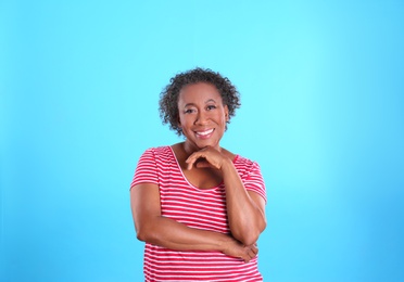 Photo of Portrait of happy African-American woman on light blue background