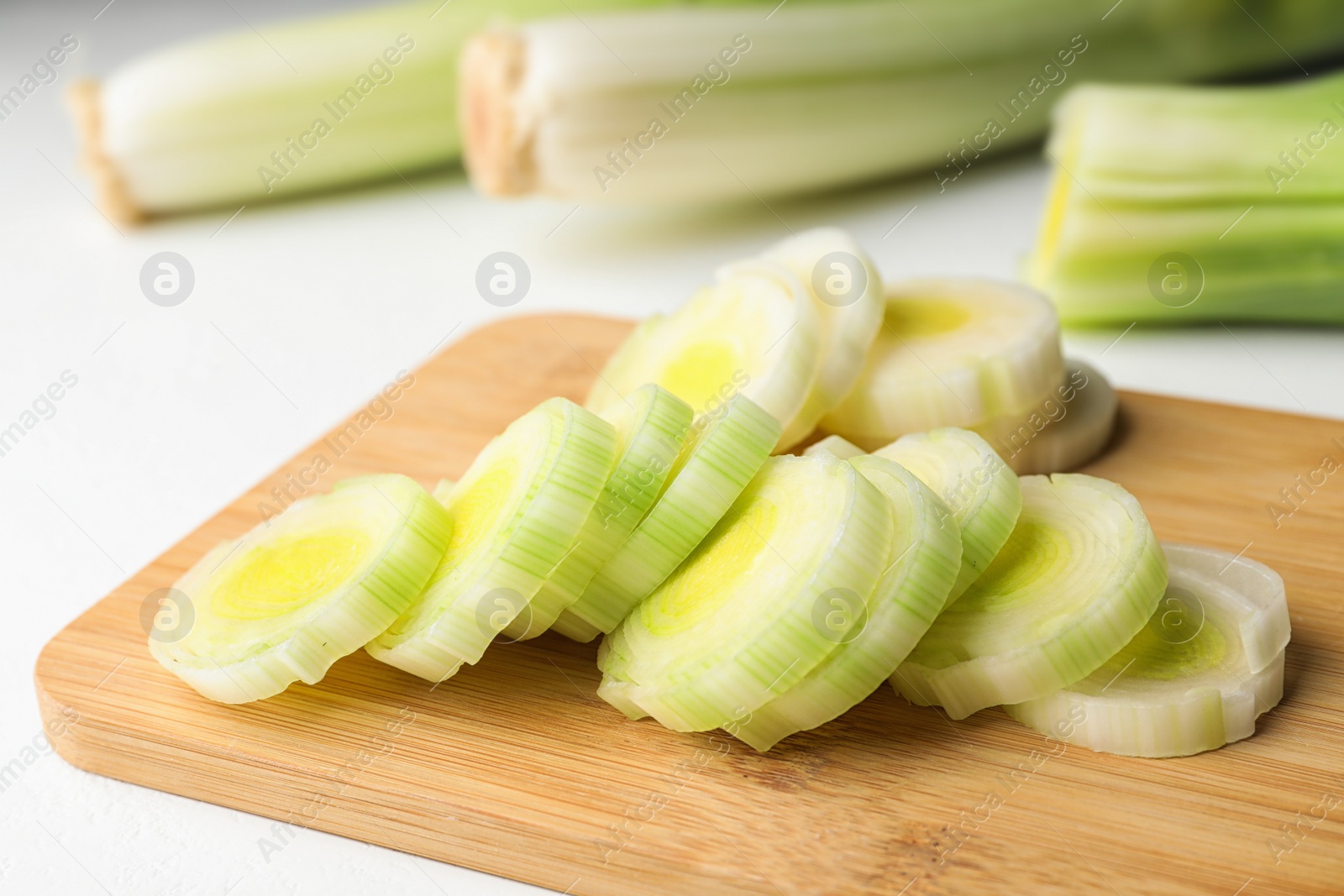 Photo of Fresh raw leek on cutting board, closeup. Ripe onion