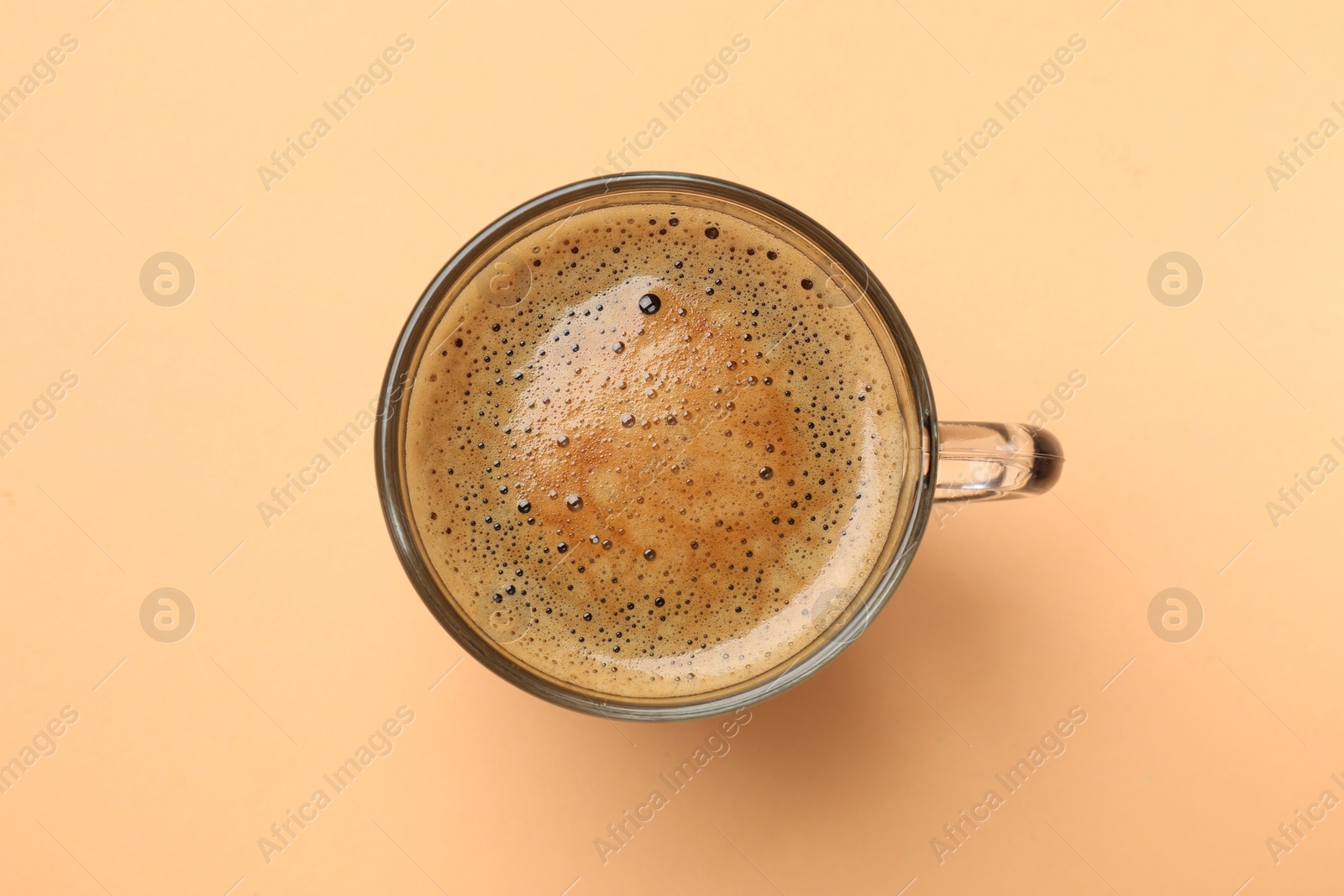 Photo of Fresh coffee in cup on beige background, top view