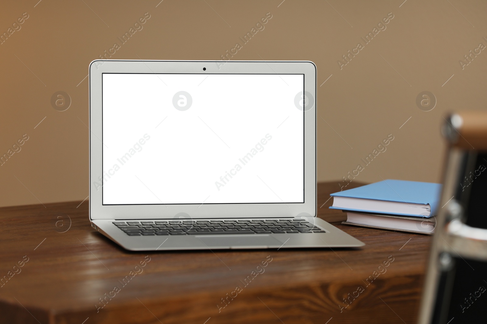 Photo of Laptop with blank screen on table indoors. Space for text