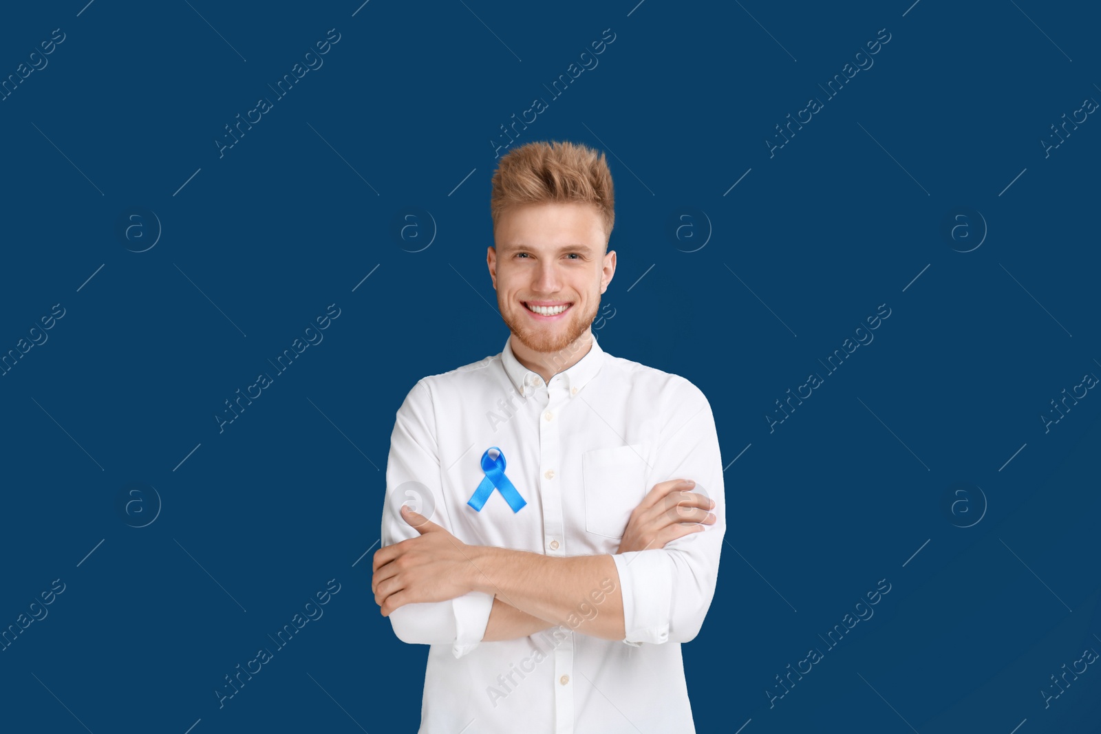 Photo of Young man with ribbon on blue background. Urology cancer awareness