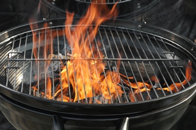 Photo of New modern barbecue grill with burning firewood, closeup