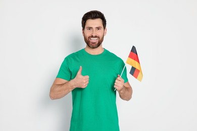 Photo of Man with flag of Germany showing thumb up on white background