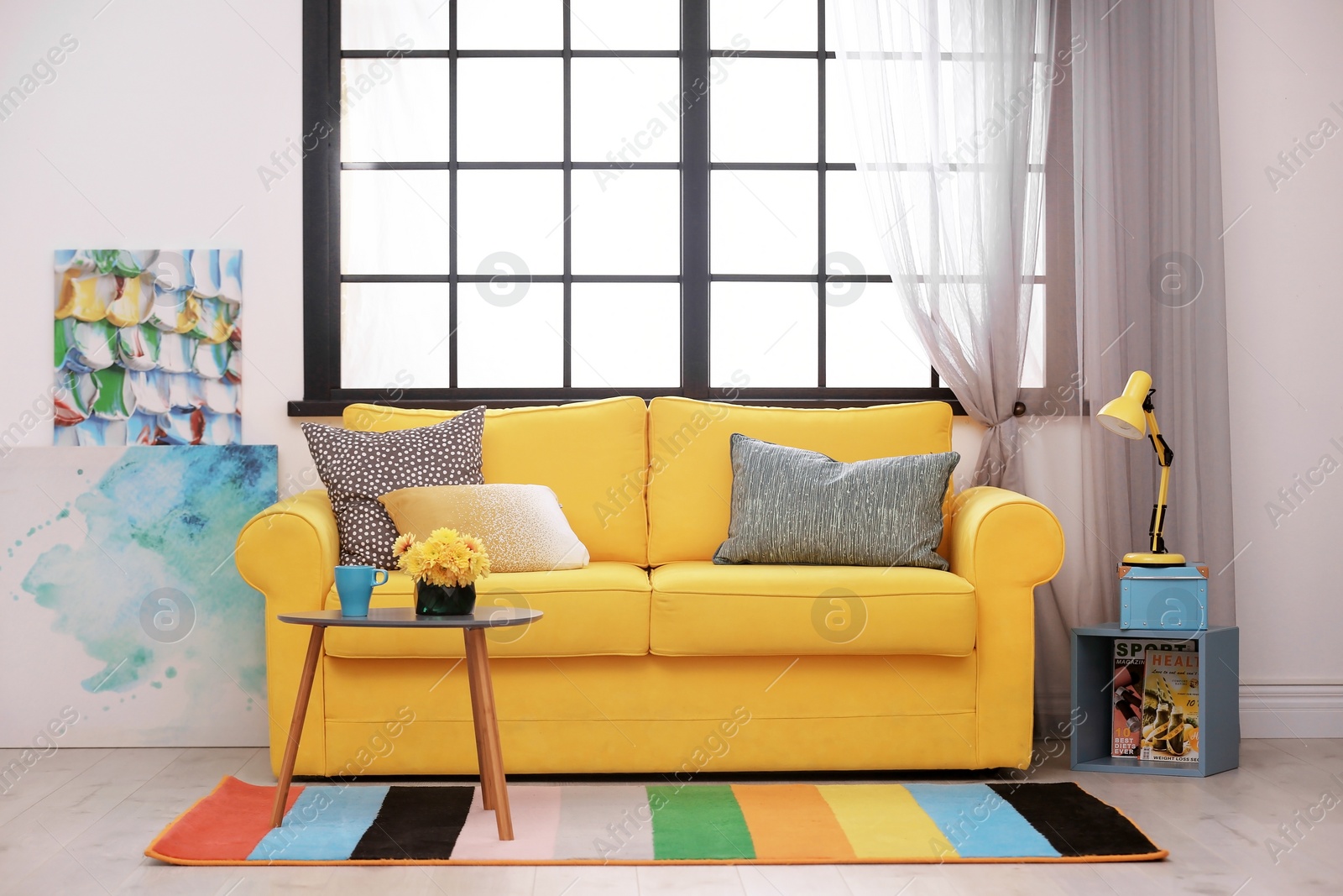 Photo of Modern room interior with comfortable sofa and rainbow carpet