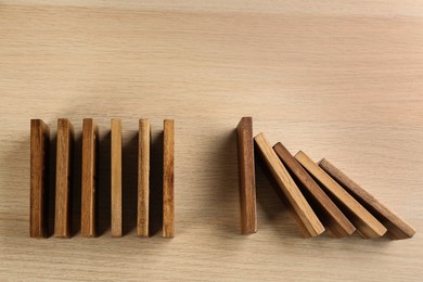 Photo of Domino tiles on wooden background, flat lay
