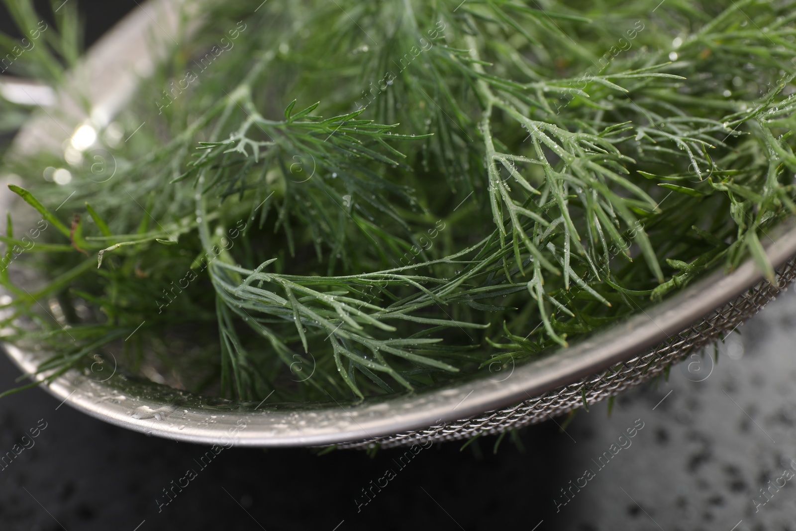Photo of Sieve with fresh dill on grey table, closeup