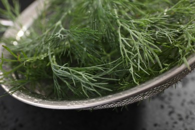 Sieve with fresh dill on grey table, closeup